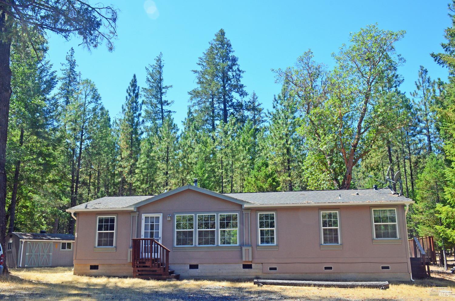 a view of a yard in front of a house with large trees