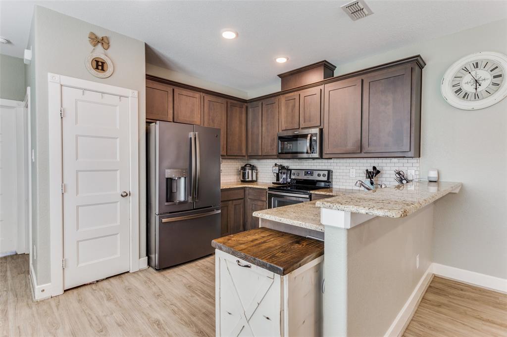 a kitchen with stainless steel appliances granite countertop a refrigerator stove and sink