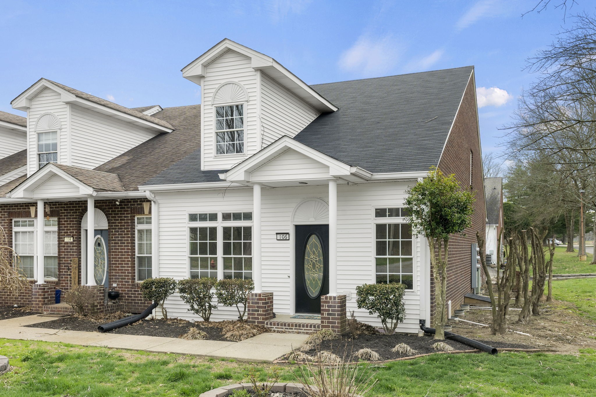 a front view of a house with yard outdoor seating and garage