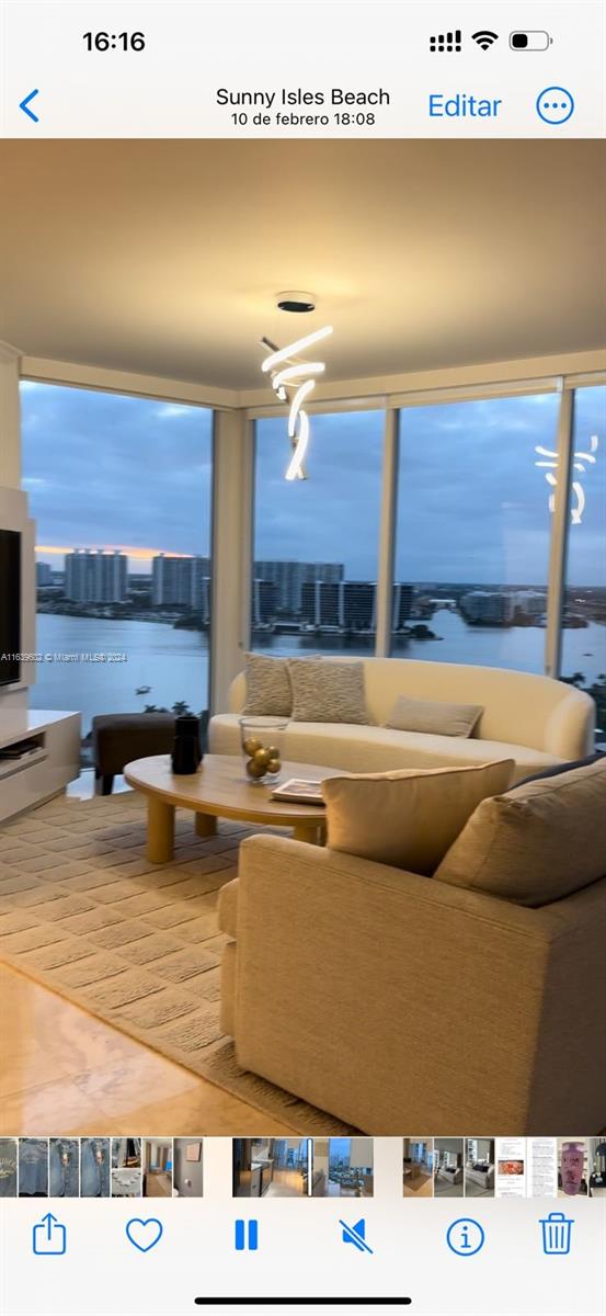 a living room with stainless steel appliances kitchen island granite countertop a sink and cabinets