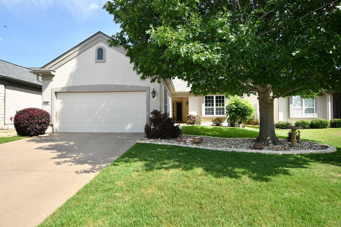 KoolCote tops the driveway and continues up the sidewalk to the porch at this ever-favorite Monroe plan which backs to a giant dedicated green space within the Sun City community.