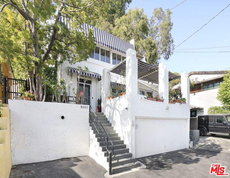 a front view of a building with large trees