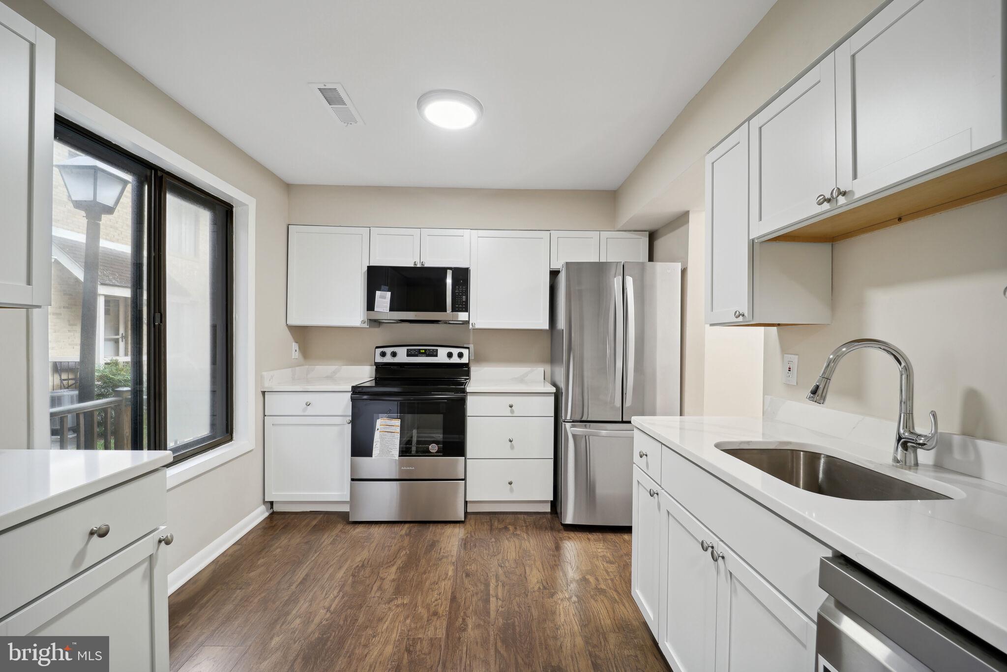 a kitchen with white cabinets and stainless steel appliances