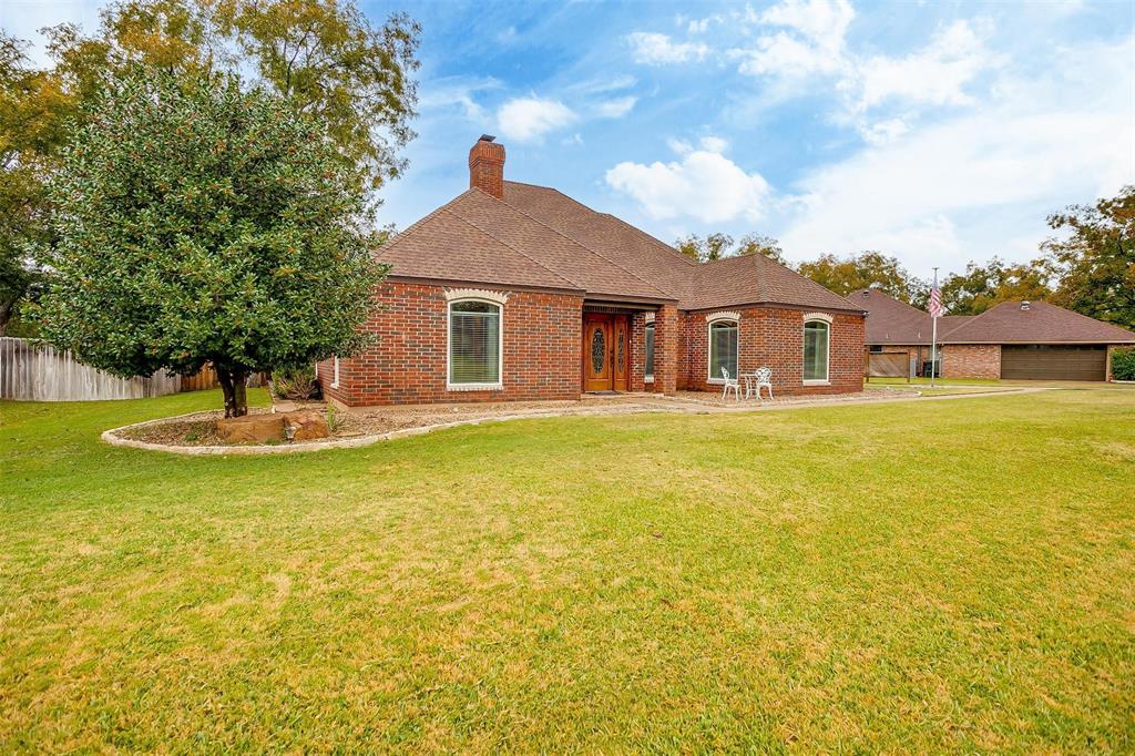 a front view of a house with yard and swimming pool