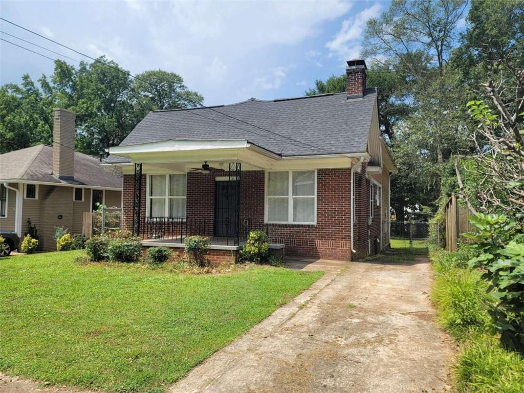 a view of a house with a yard and sitting area