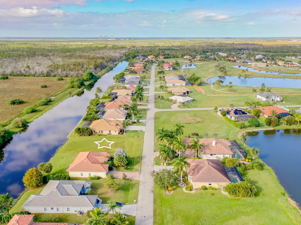 an aerial view of ocean and residential houses with outdoor space