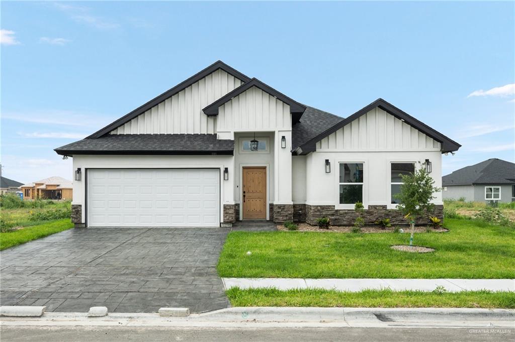 Modern farmhouse style home with a garage and a front yard