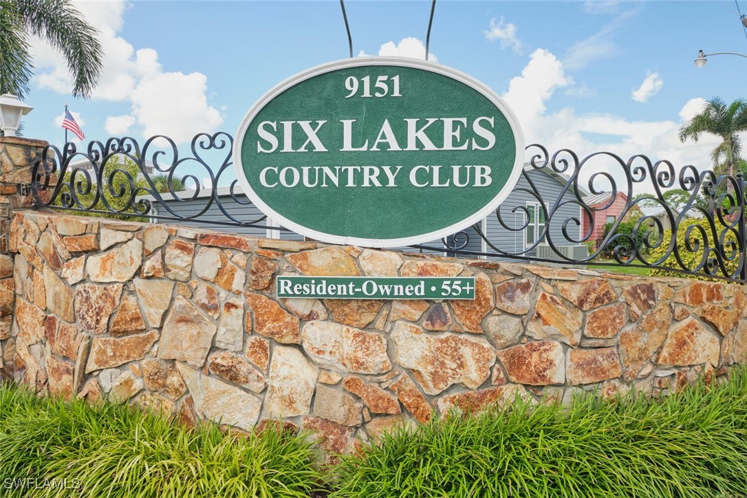 a sign board with a wooden fence