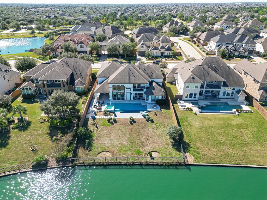 an aerial view of a house with a garden and lake view