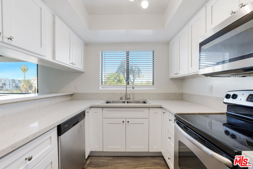 a kitchen with a sink stove top oven and cabinets