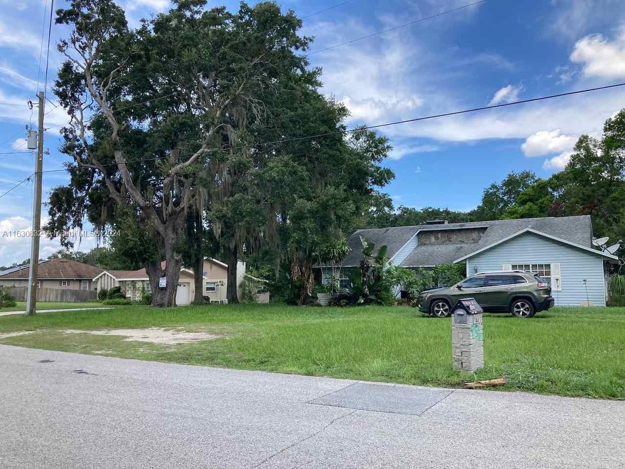 a view of a house with a yard and tree s