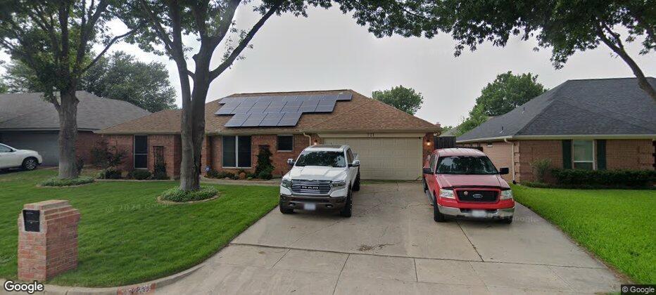 a car parked in front of a house and a garden