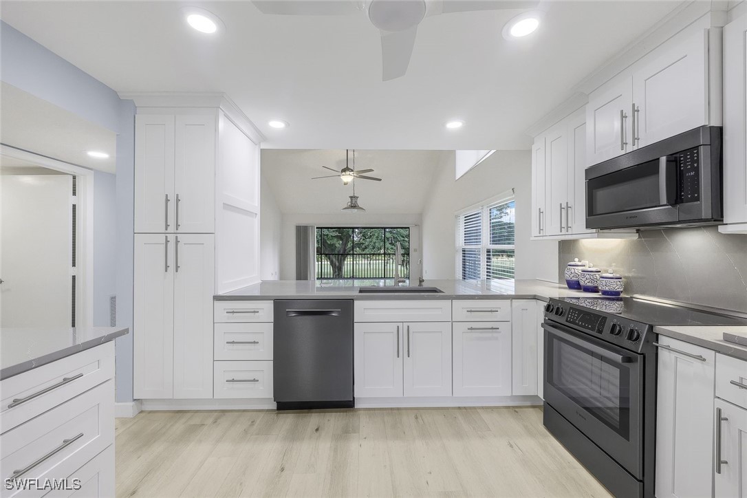 a kitchen with stainless steel appliances granite countertop a stove a sink and a refrigerator