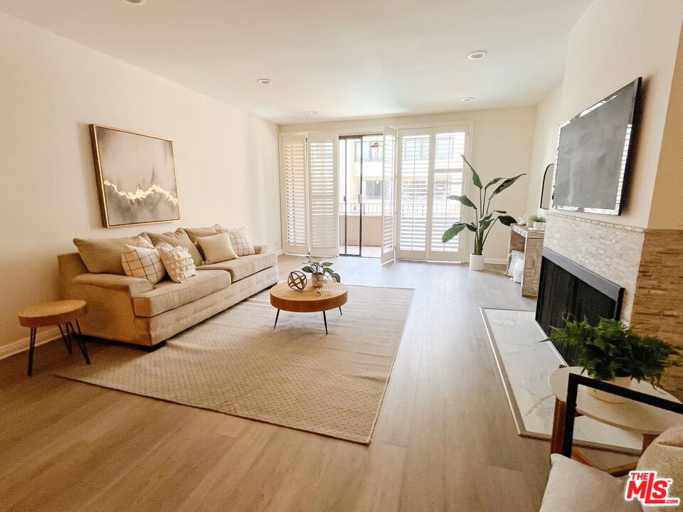 a living room with furniture fireplace and a large window