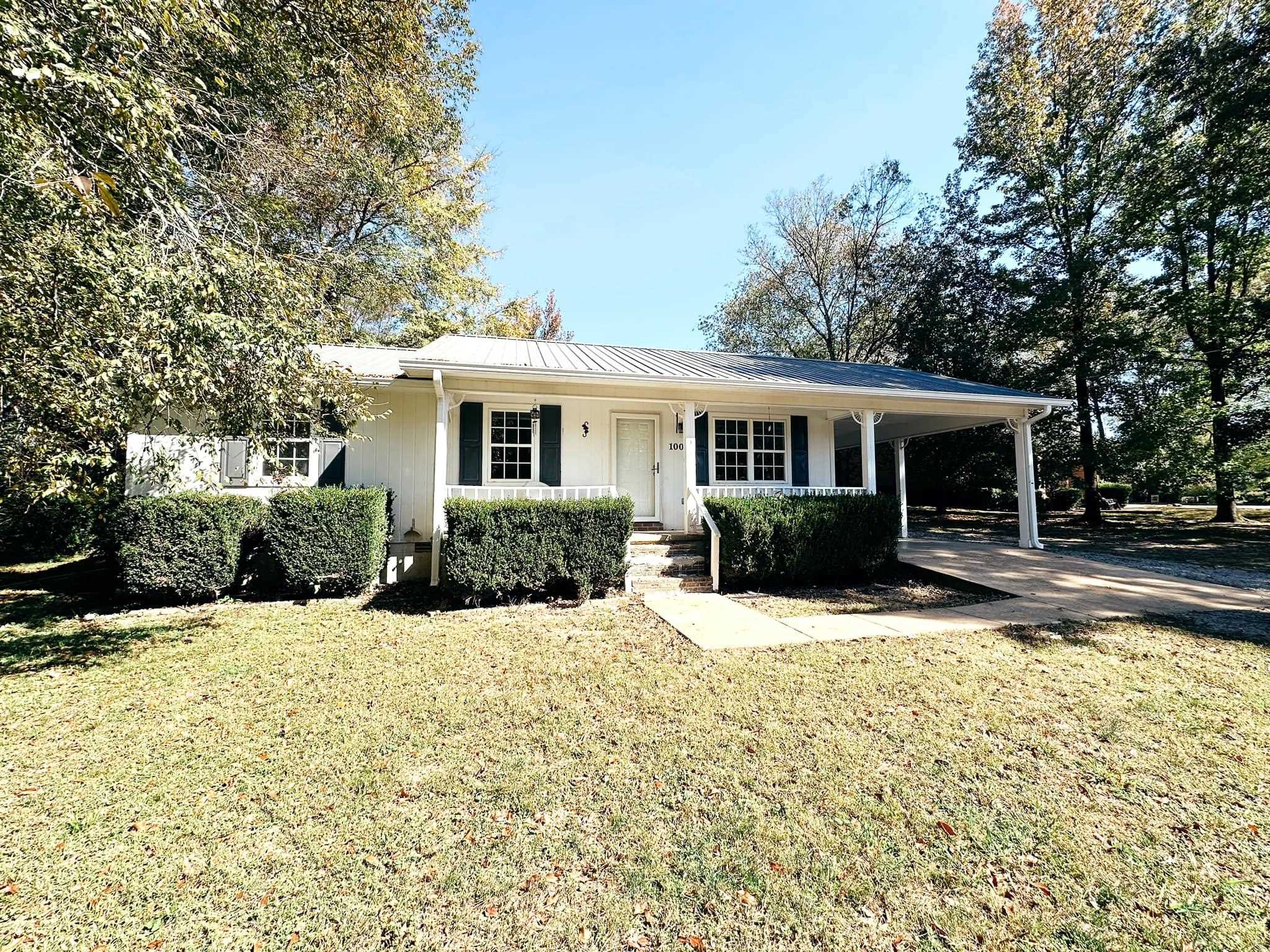 a view of a house with a yard covered with trees