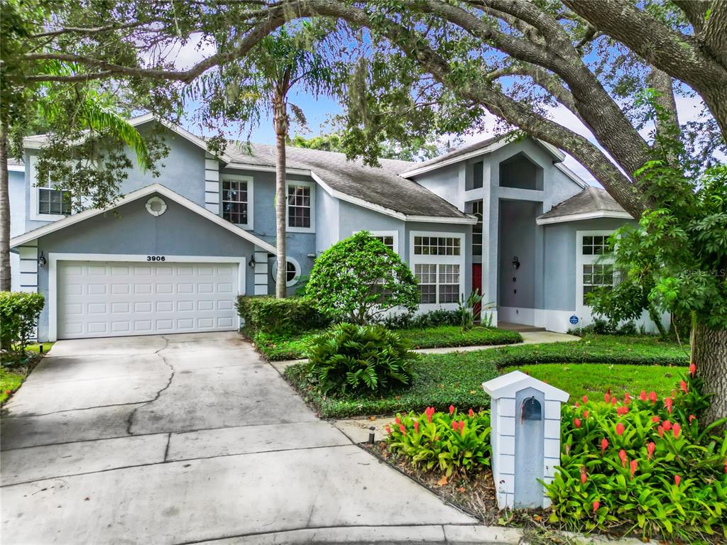 a front view of a house with a yard and trees