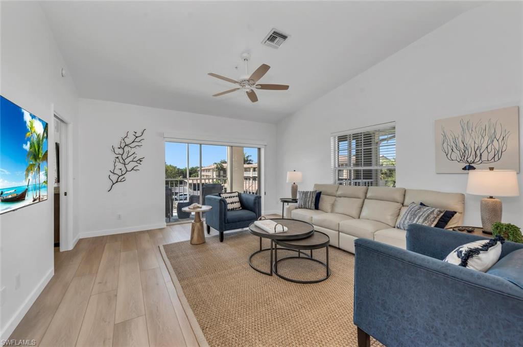 a living room with furniture a ceiling fan and a rug