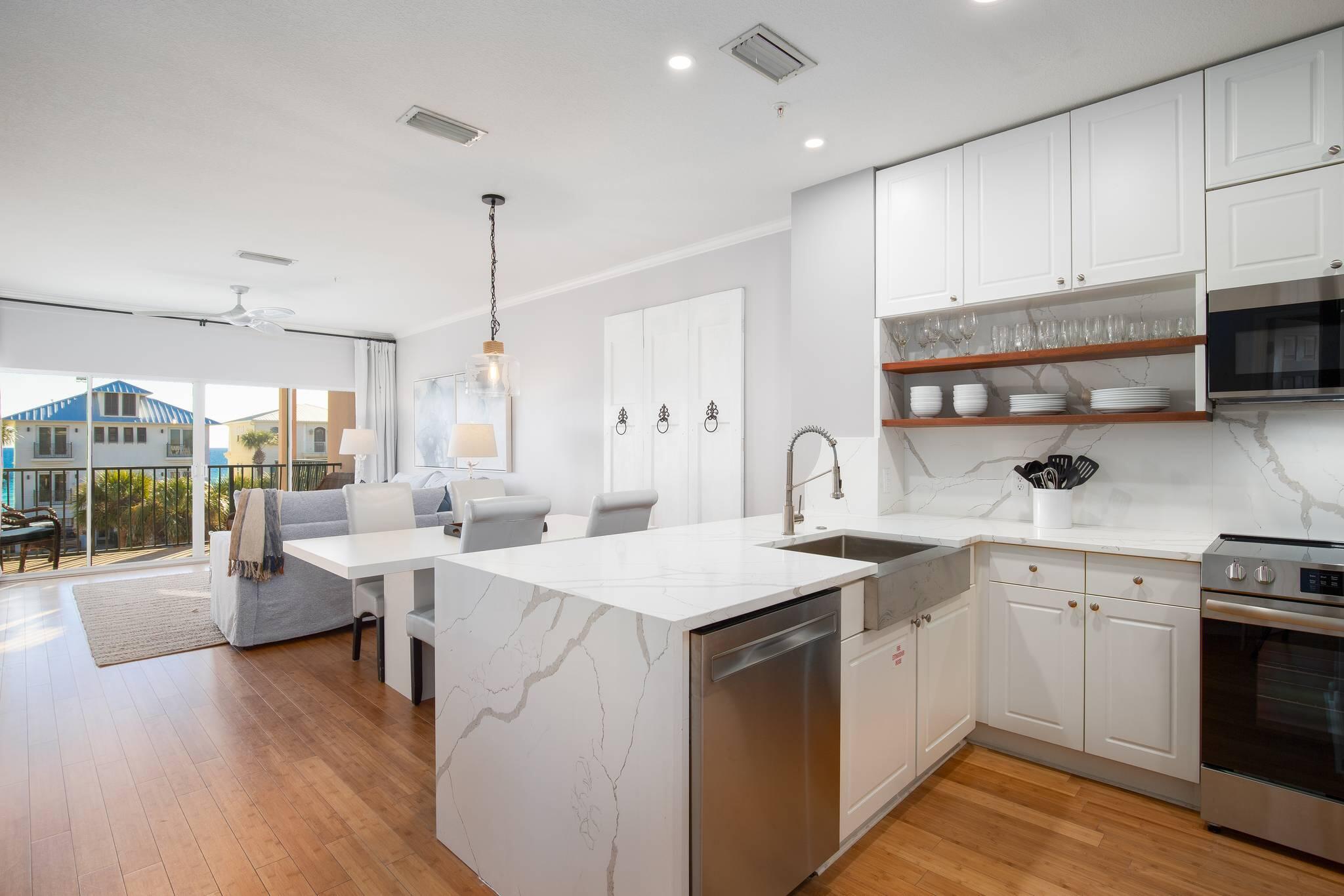 a open kitchen with sink stove and white cabinets with wooden floor