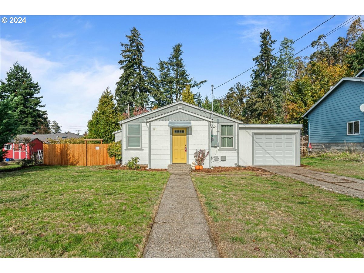 a front view of a house with a yard and trees