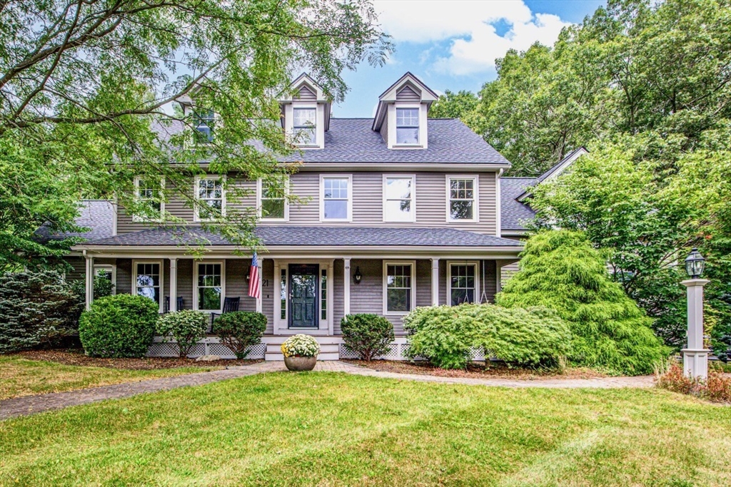 a front view of a house with yard and green space