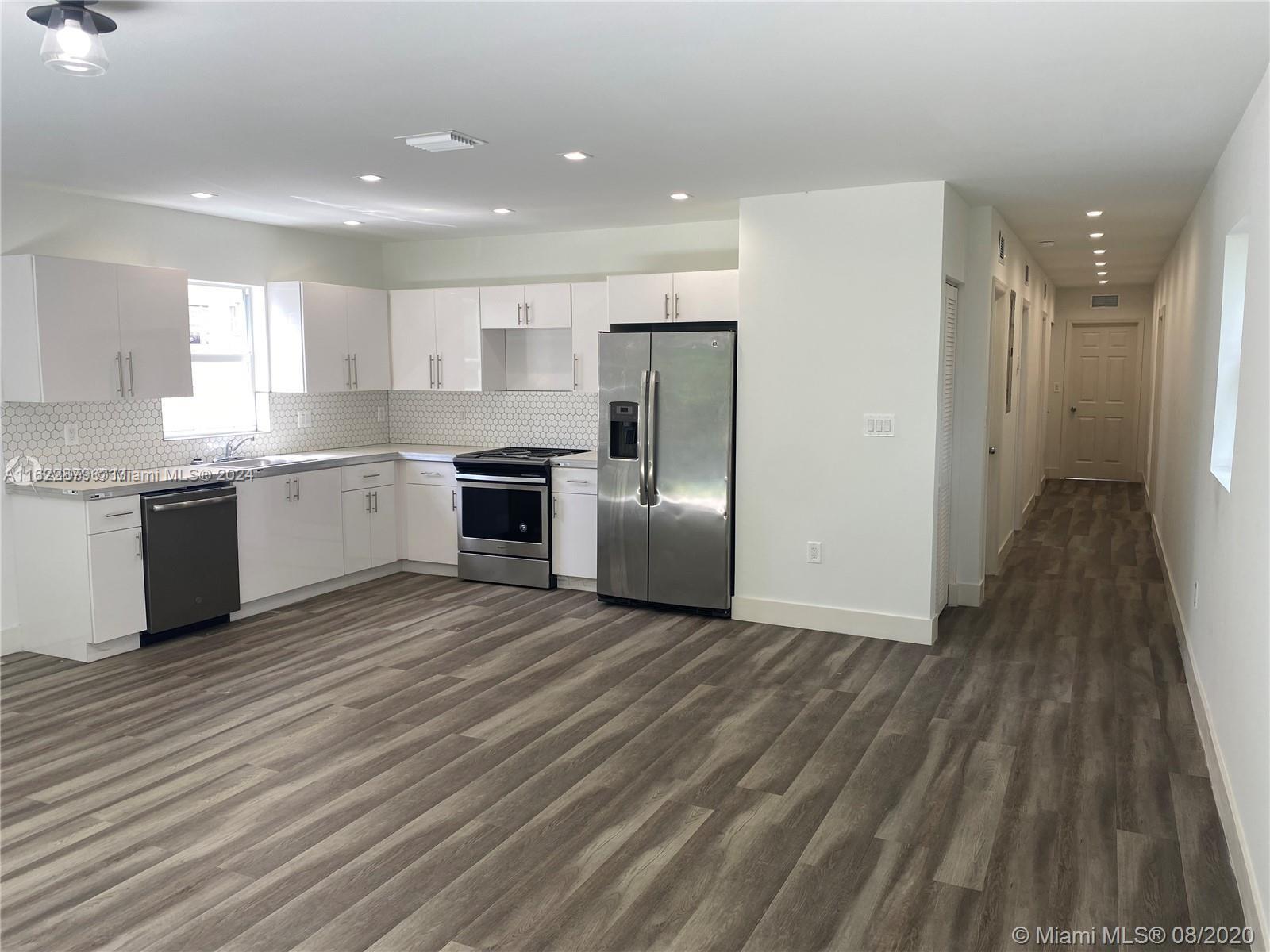 a large kitchen with stainless steel appliances granite countertop a stove and a refrigerator