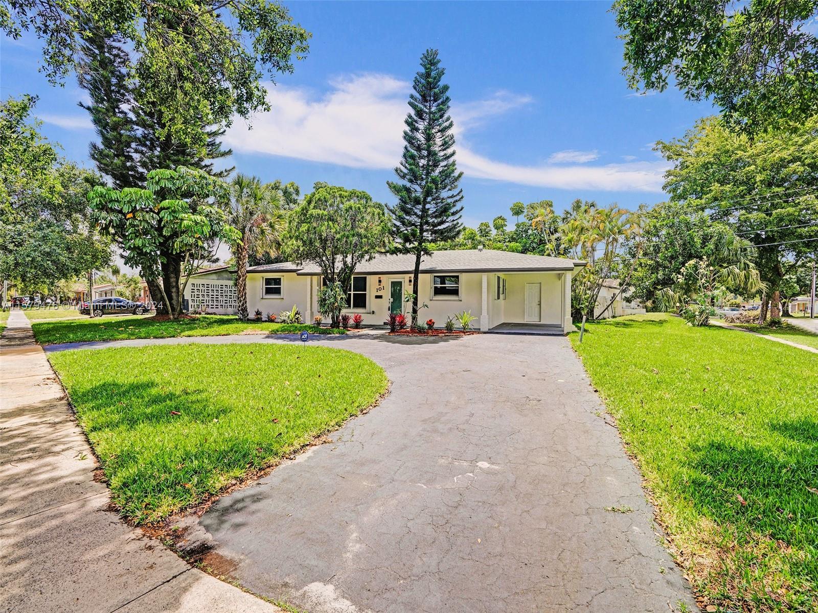 a view of house with a big yard and potted plants