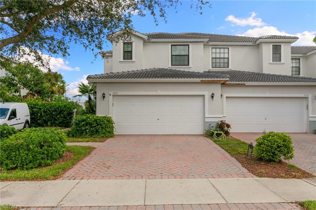 a front view of a house with a yard and a garage