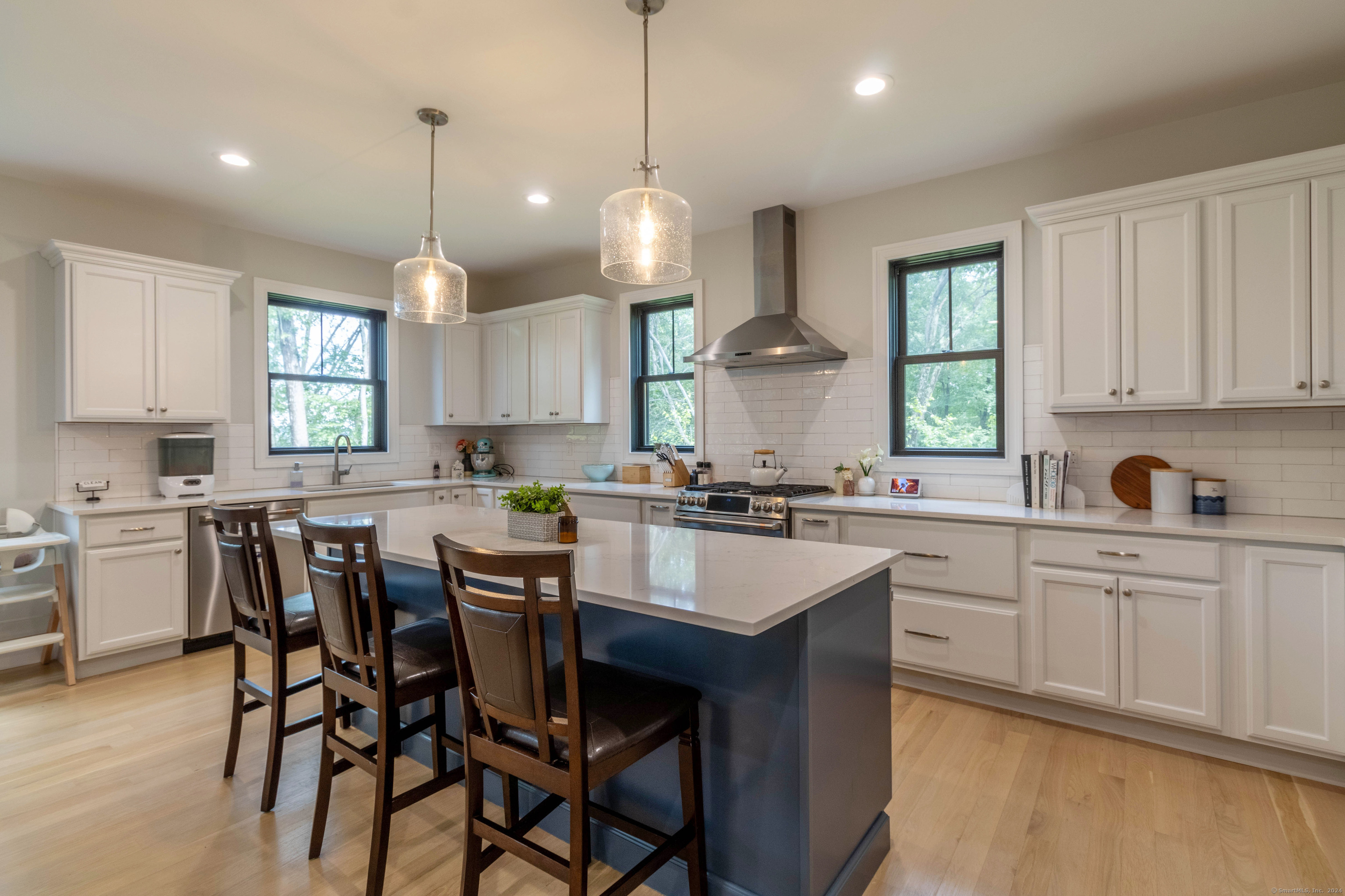 a large kitchen with cabinets a sink a window and chairs in it