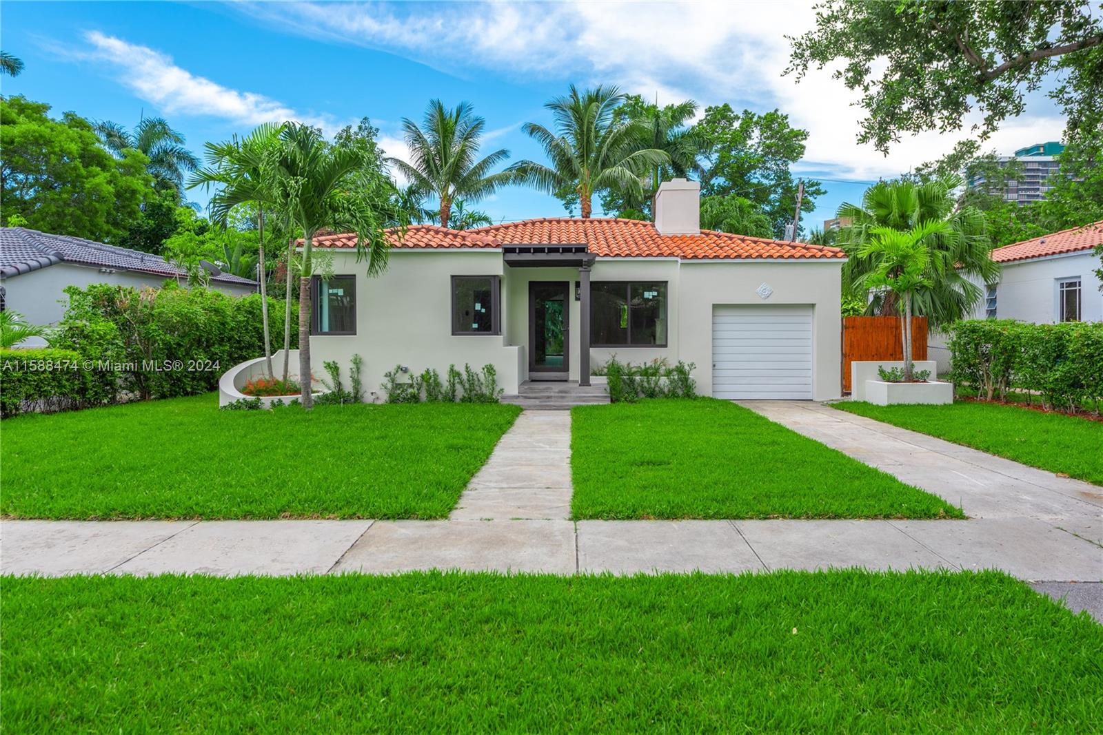 a front view of a house with a garden and yard