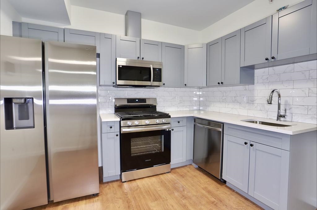 a kitchen with white cabinets stainless steel appliances and sink