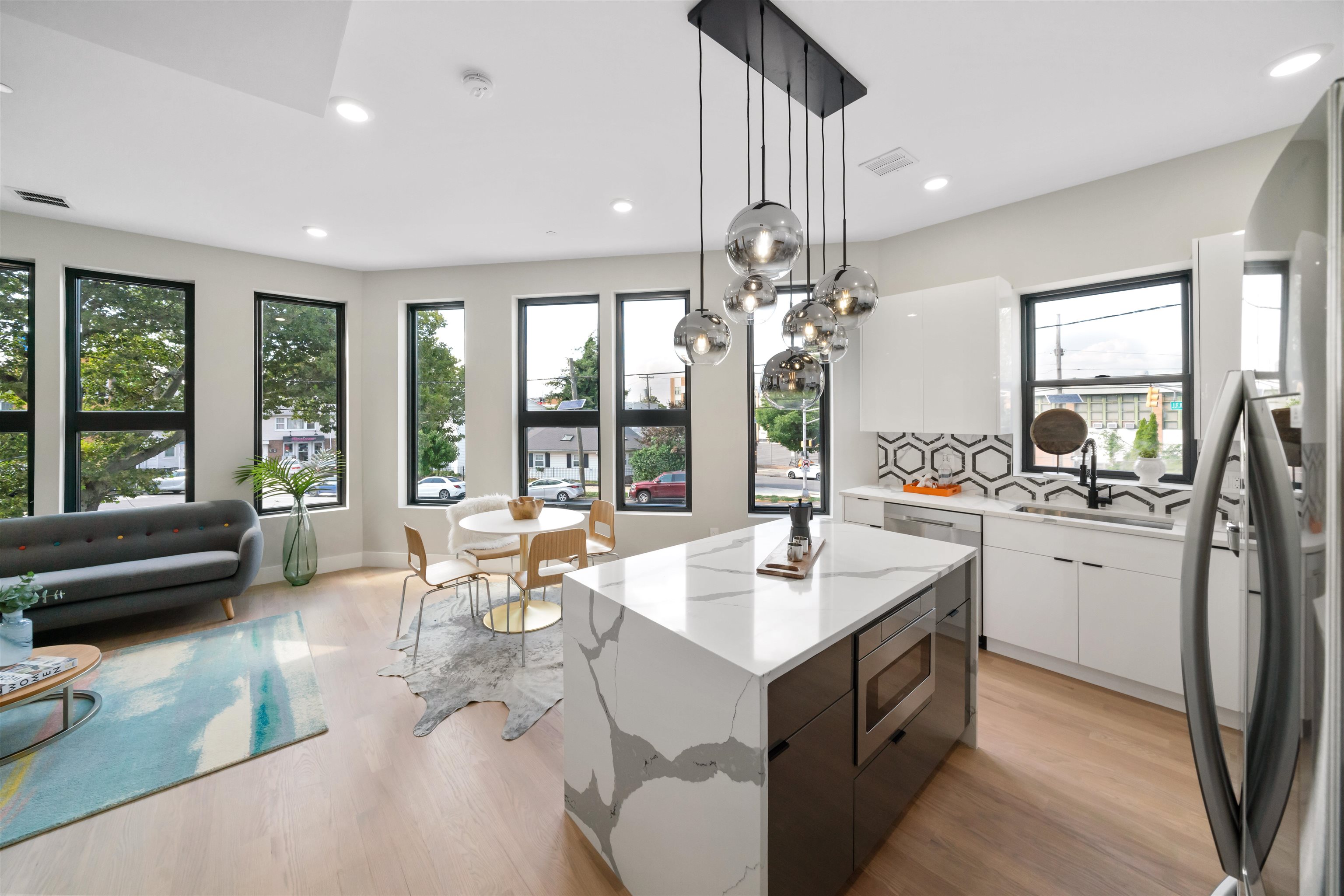 a large white kitchen with a large window and stainless steel appliances