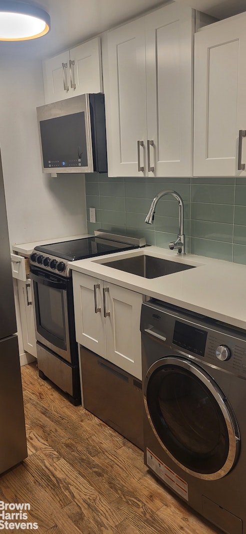 a kitchen with a sink cabinets and stainless steel appliances