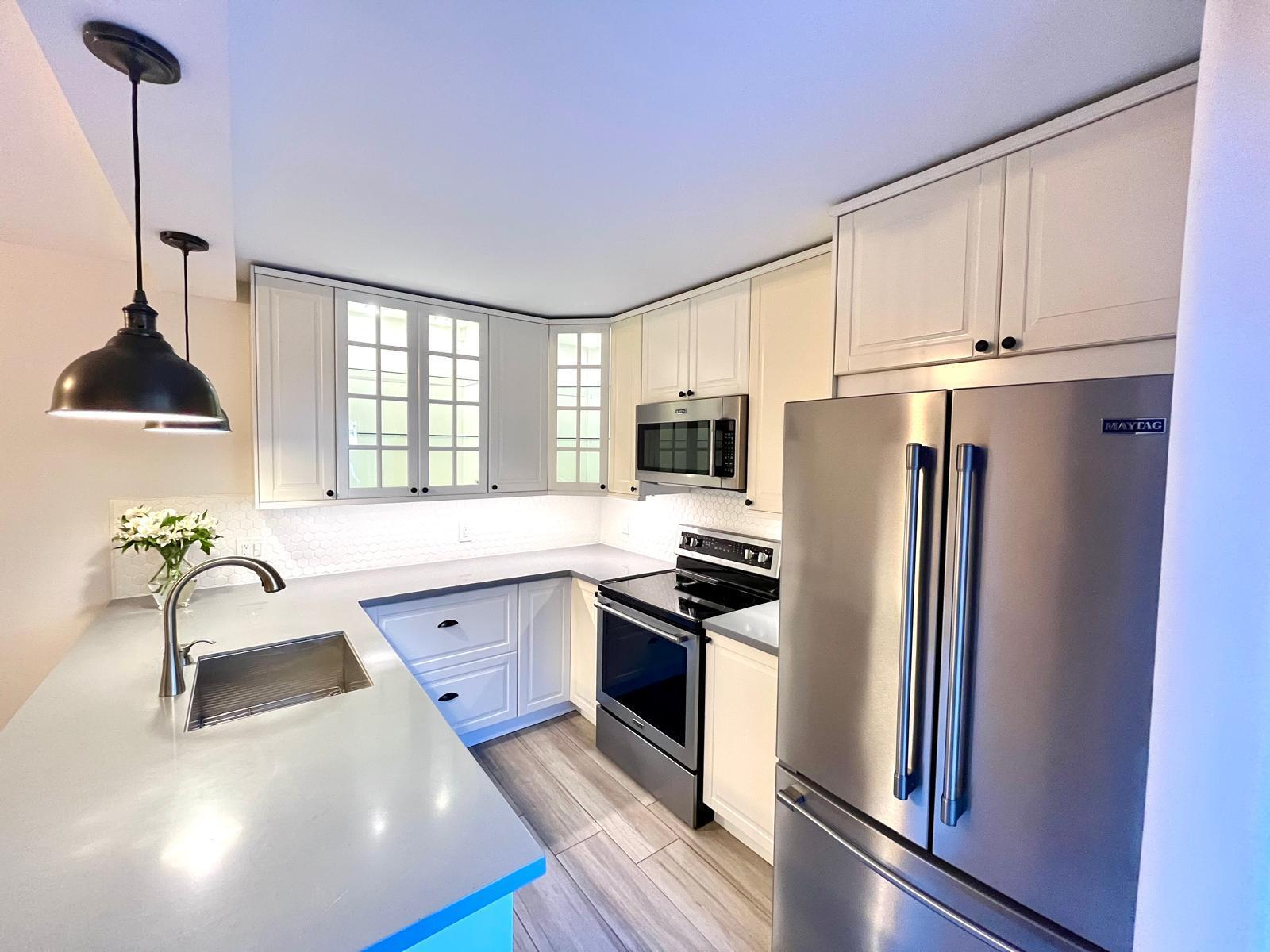 a kitchen with stainless steel appliances a refrigerator sink and stove