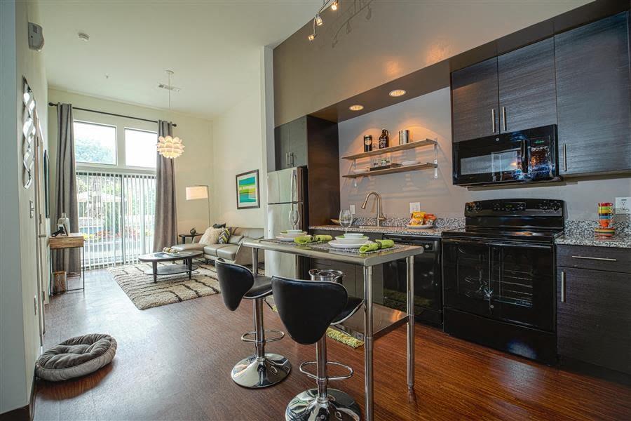 a kitchen with a table chairs a stove and a window