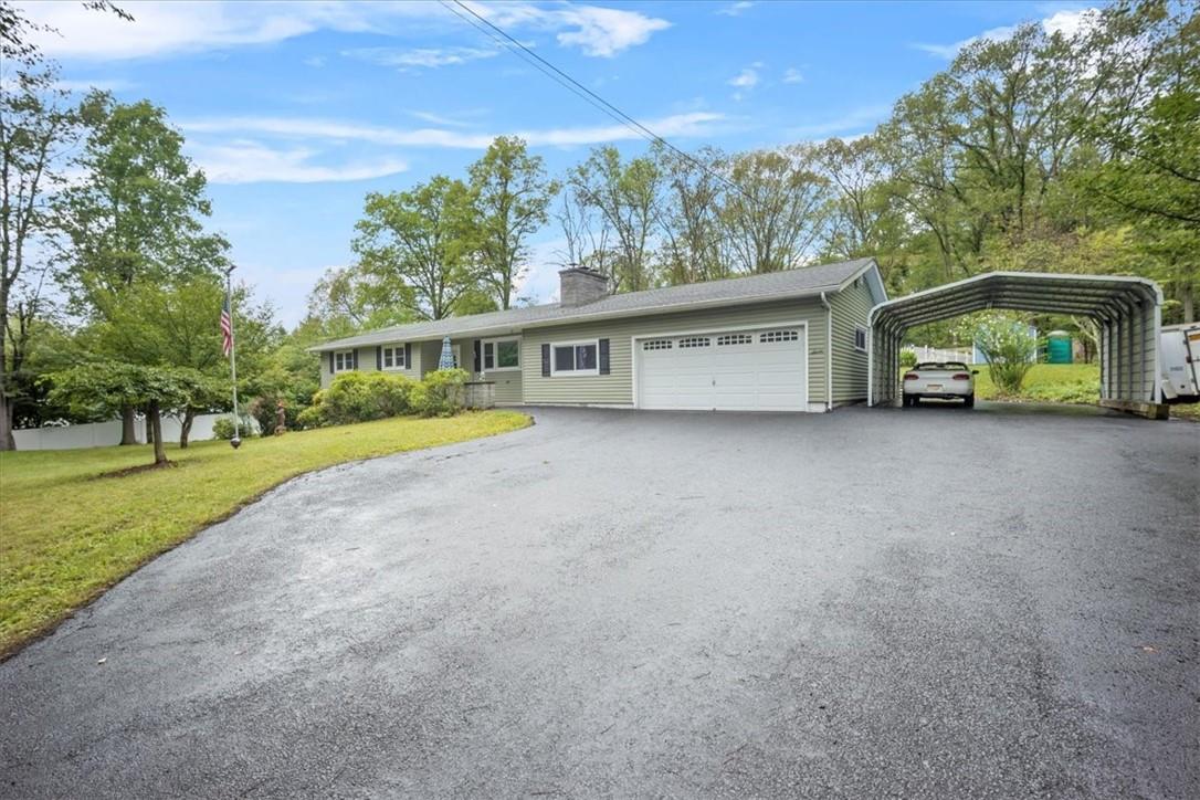 Ranch-style home with a garage, a carport, and a front lawn