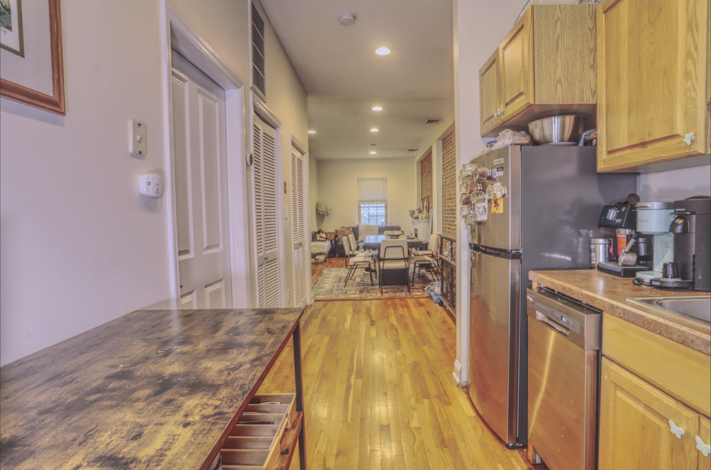 a view of a kitchen with kitchen island a counter top space a sink and cabinets