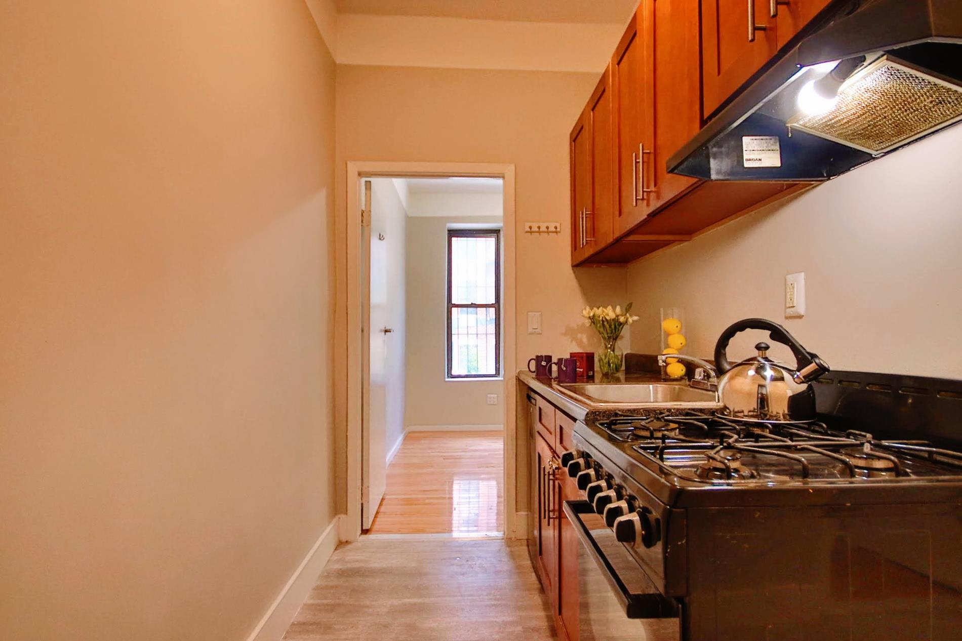 a kitchen with a stove and a wooden floor