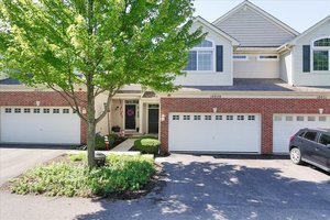 a front view of a house with a garden and garage