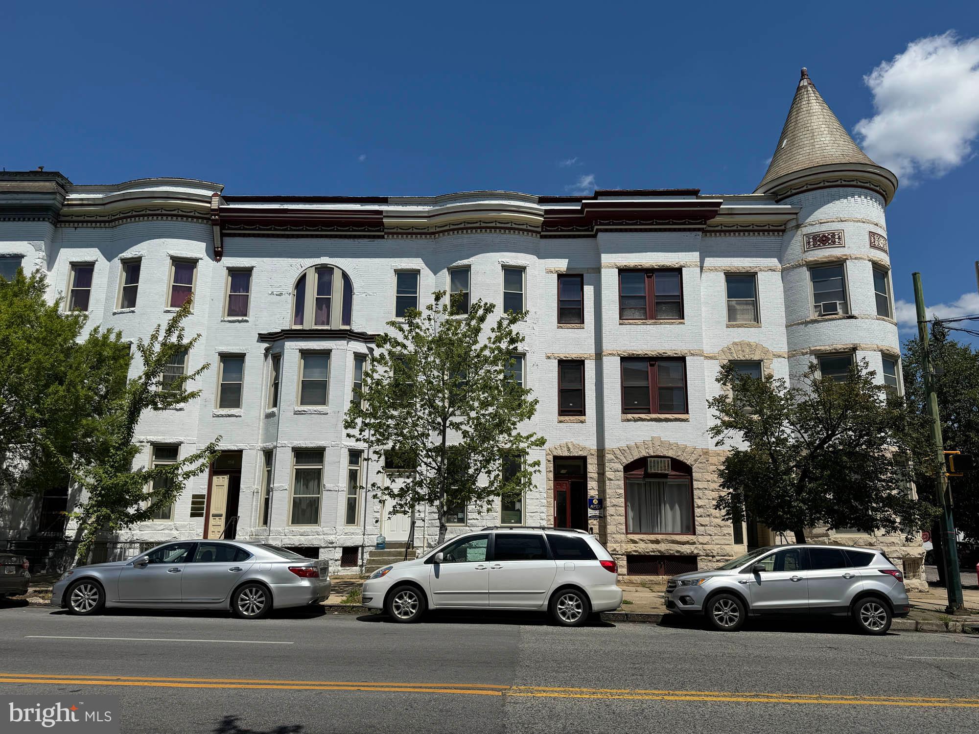 a view of a building and car parked on the roadside