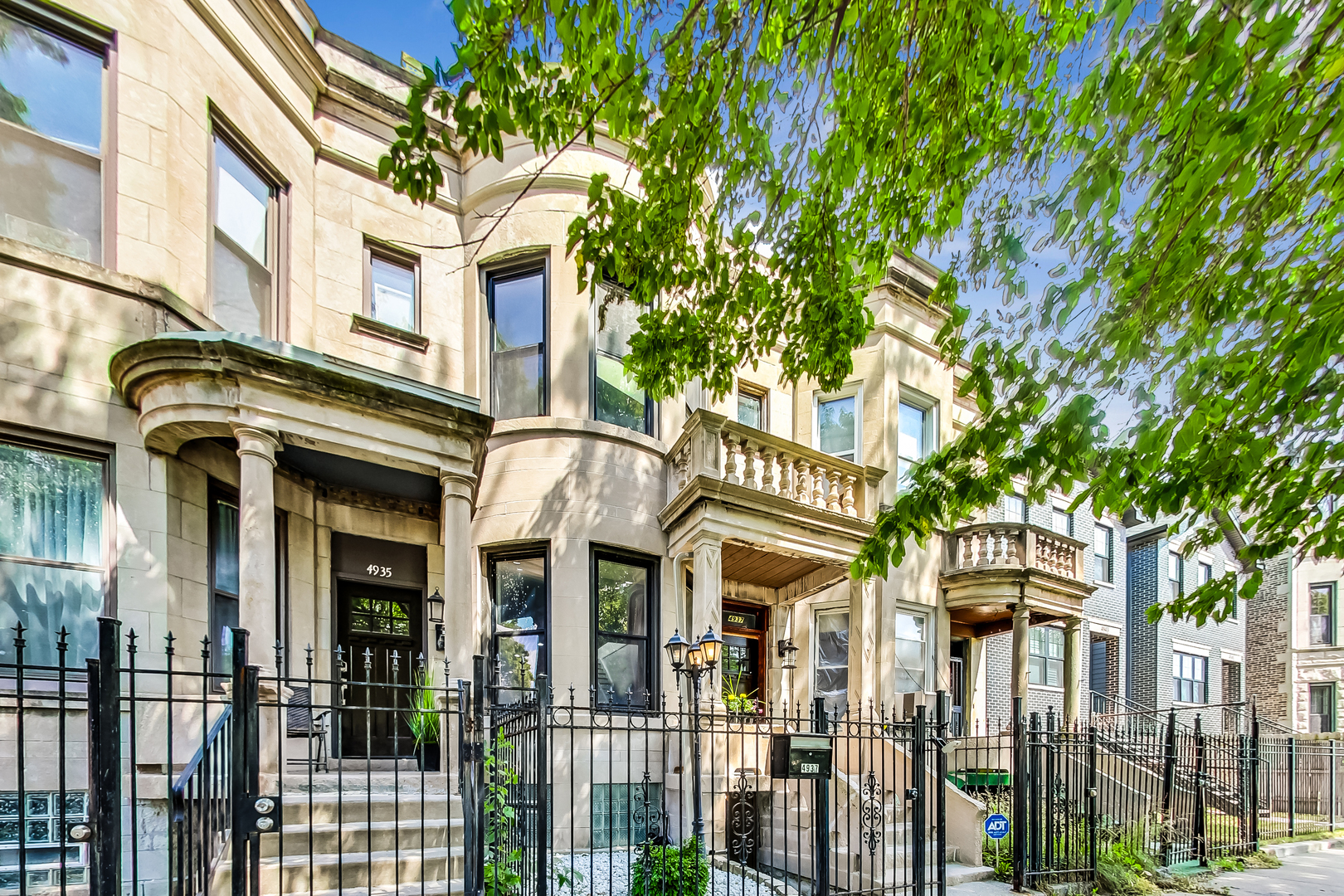 a front view of a residential apartment building with a small yard