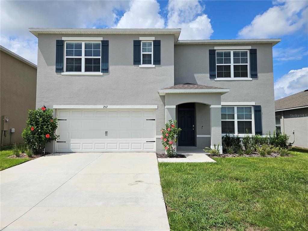 a front view of a house with a yard and garage