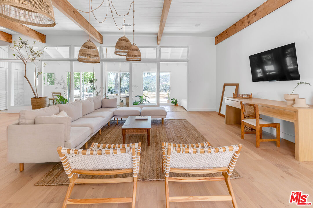 a living room with furniture a flat screen tv and a large window