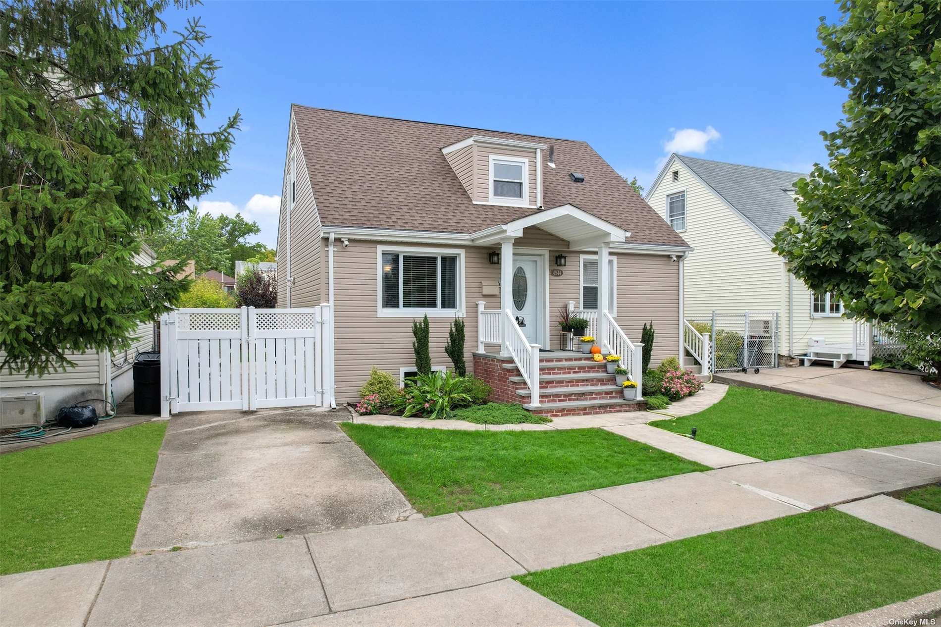 a front view of a house with a yard and potted plants