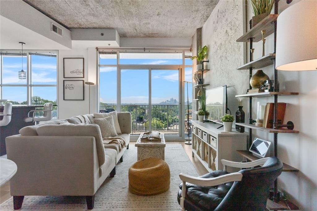 a living room with furniture a large window and flat screen tv