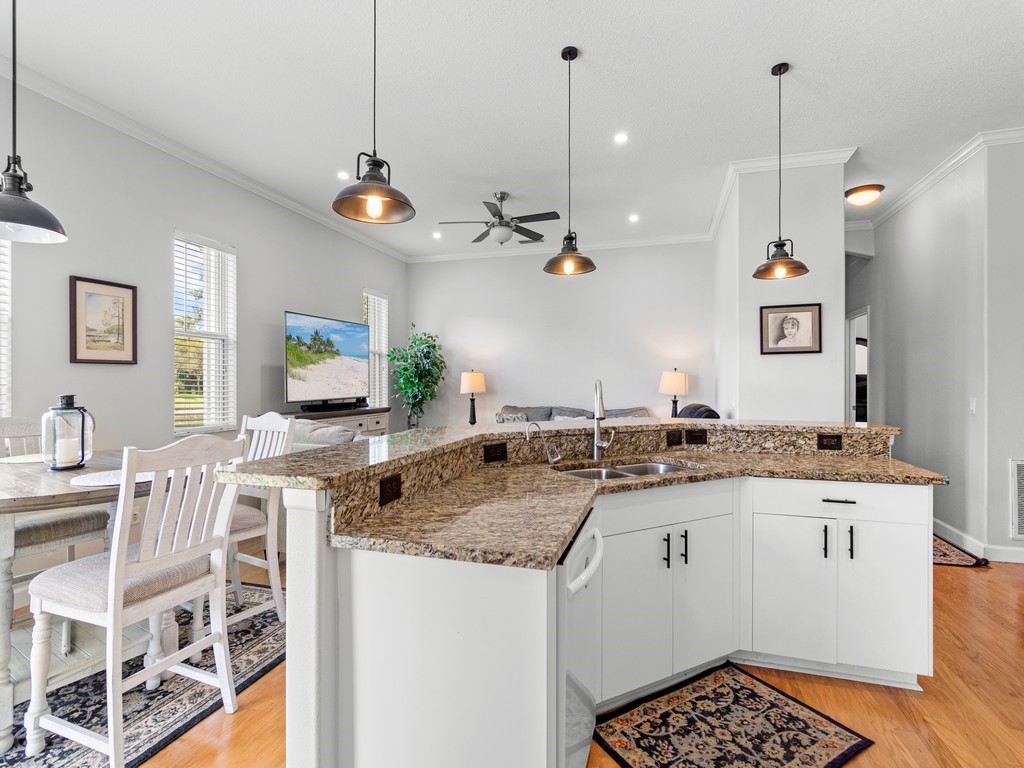 a view of a kitchen with kitchen island granite countertop a sink and a stove