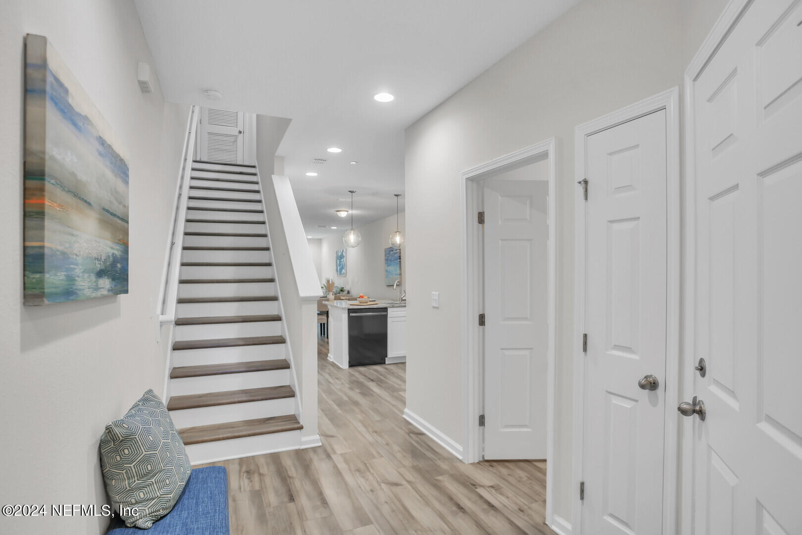 a view of a hallway with wooden floor and entryway