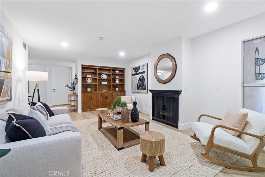 a living room with furniture a fireplace and a large window