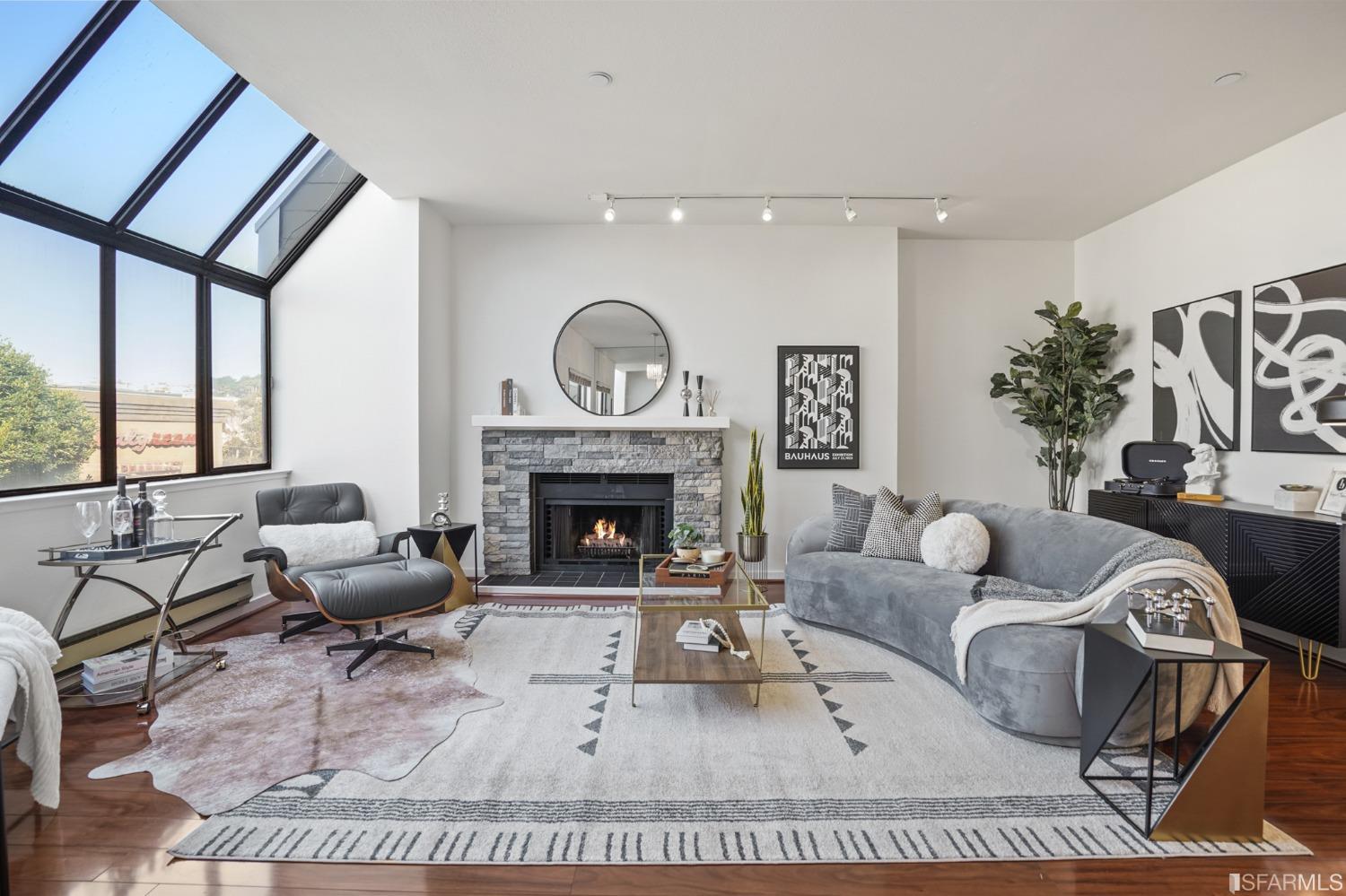 a living room with furniture a large window and a fireplace