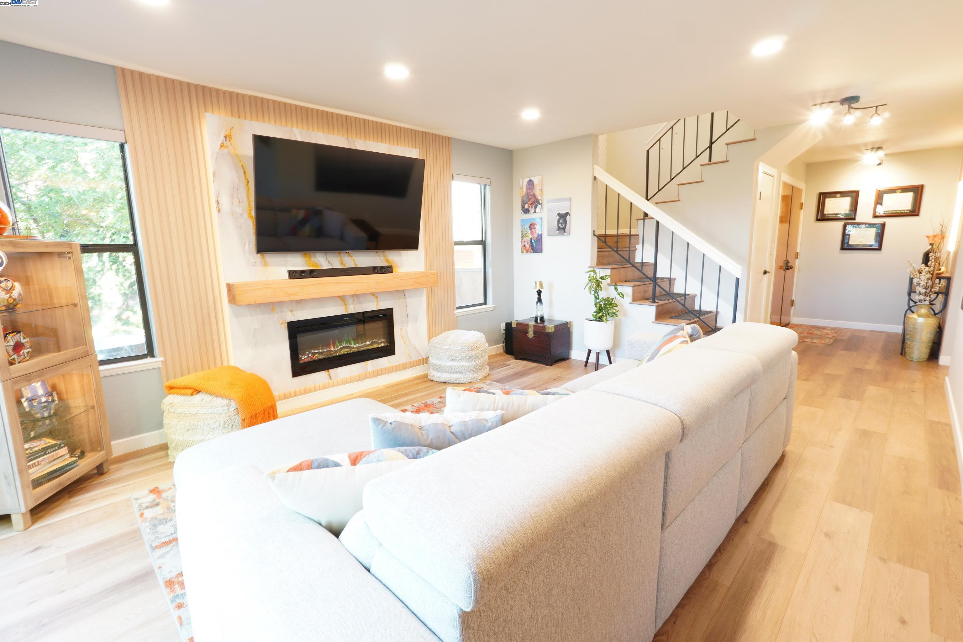 a living room with furniture a flat screen tv and a fireplace