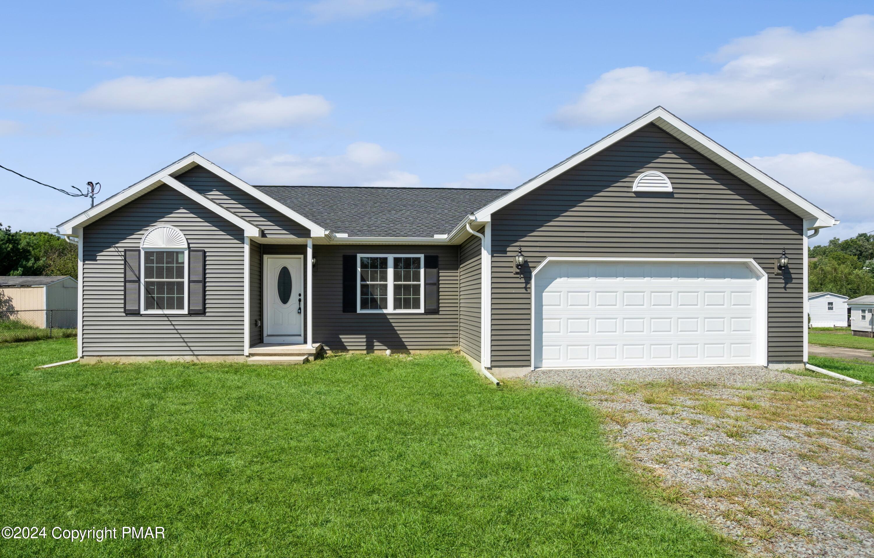 a front view of a house with yard and green space